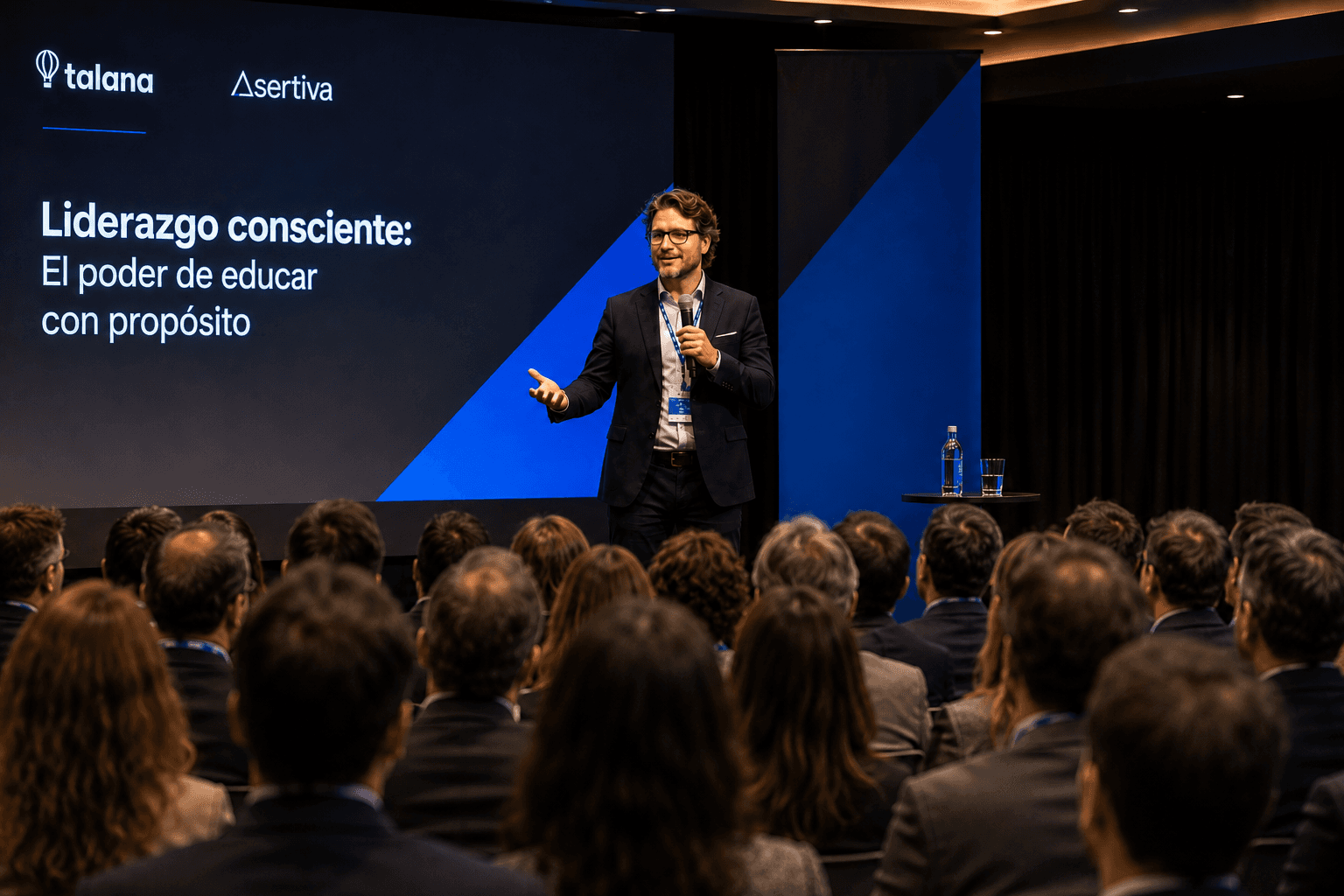 Lucas Carballo en escenario hablando frente a una audiencia, con slide proyectado al fondo.